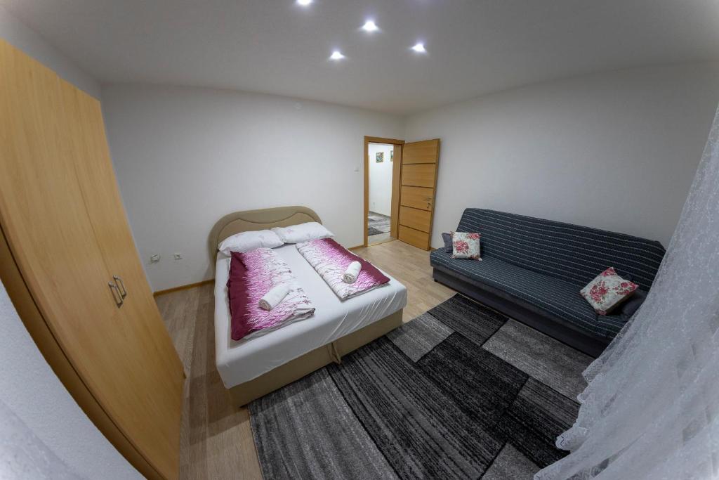 Habitación pequeña con cama y sofá en Apartments Aqua Resa, en Bihać