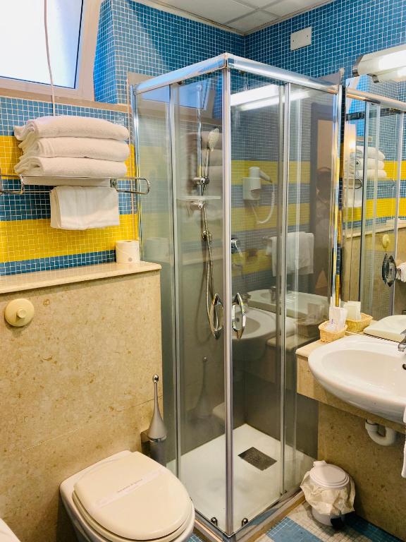 a bathroom with a shower and a toilet and a sink at Hotel Della Baia in Portovenere