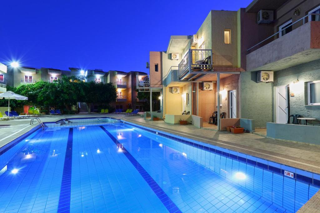 a swimming pool in a hotel at night at Cosman Hotel in Kokkíni Khánion