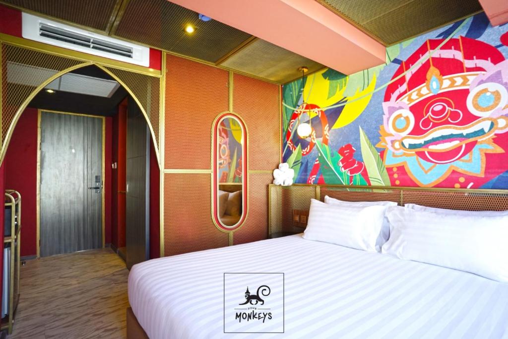 een slaapkamer met een groot bed en een schilderij aan de muur bij 4 Monkeys Hotel in Bangkok