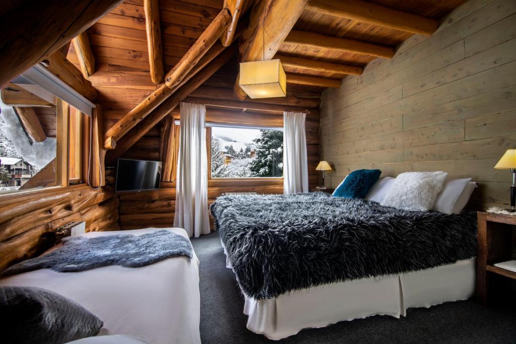 una camera con due letti e una finestra di Hosteria Sudbruck a San Carlos de Bariloche