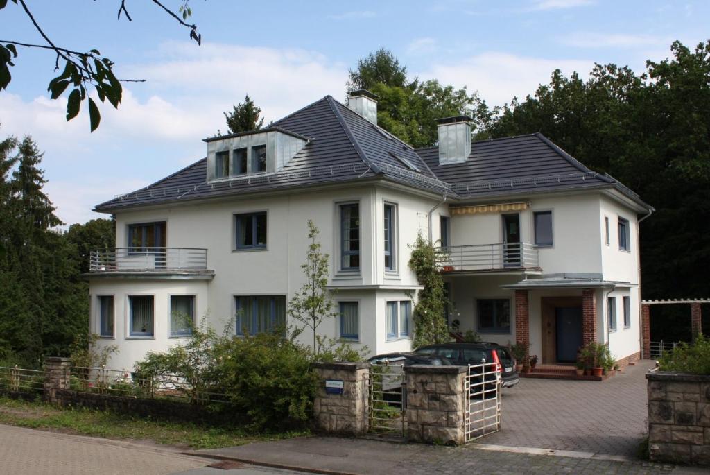 une maison blanche avec un toit noir dans l'établissement Villa Brodthage, App. 1, à Walkenried
