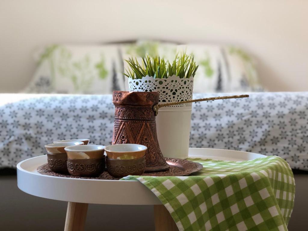 een tafel met drie bekers en een vaas met planten bij Apartment Incognito in Sarajevo