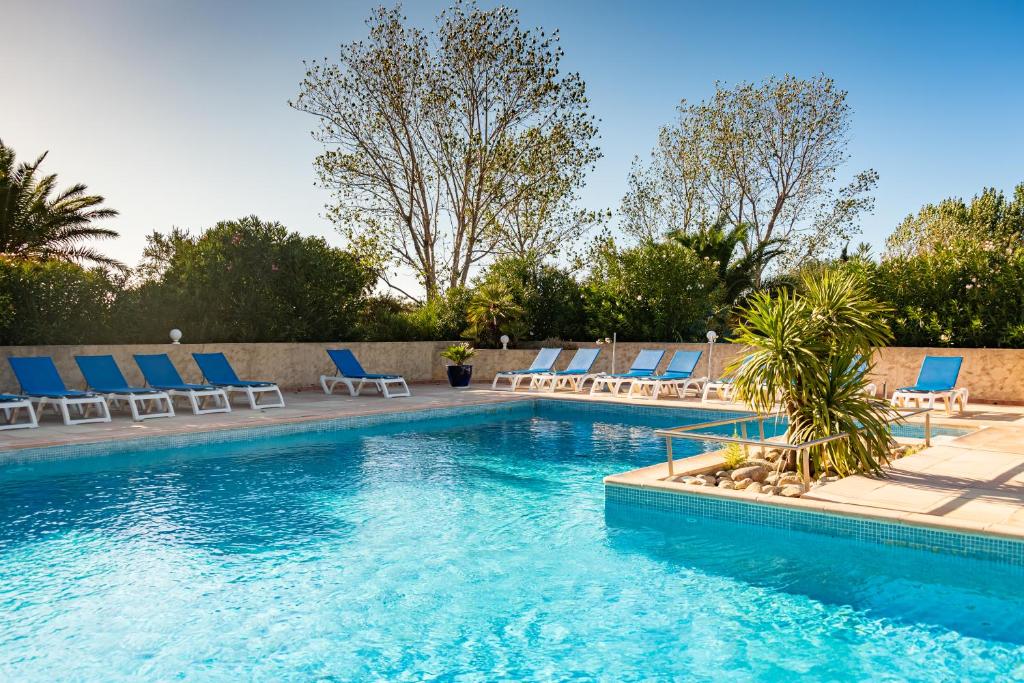 una piscina con sedie a sdraio e una piscina di Résidence Spelonca a Corbara