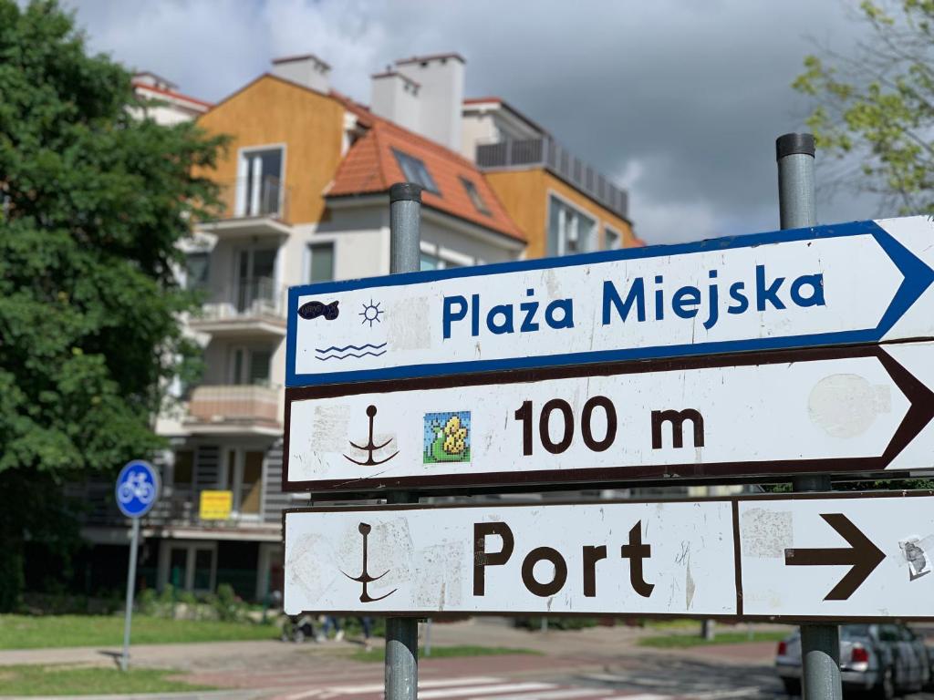 three street signs on a pole in a city at Apartament45 in Giżycko