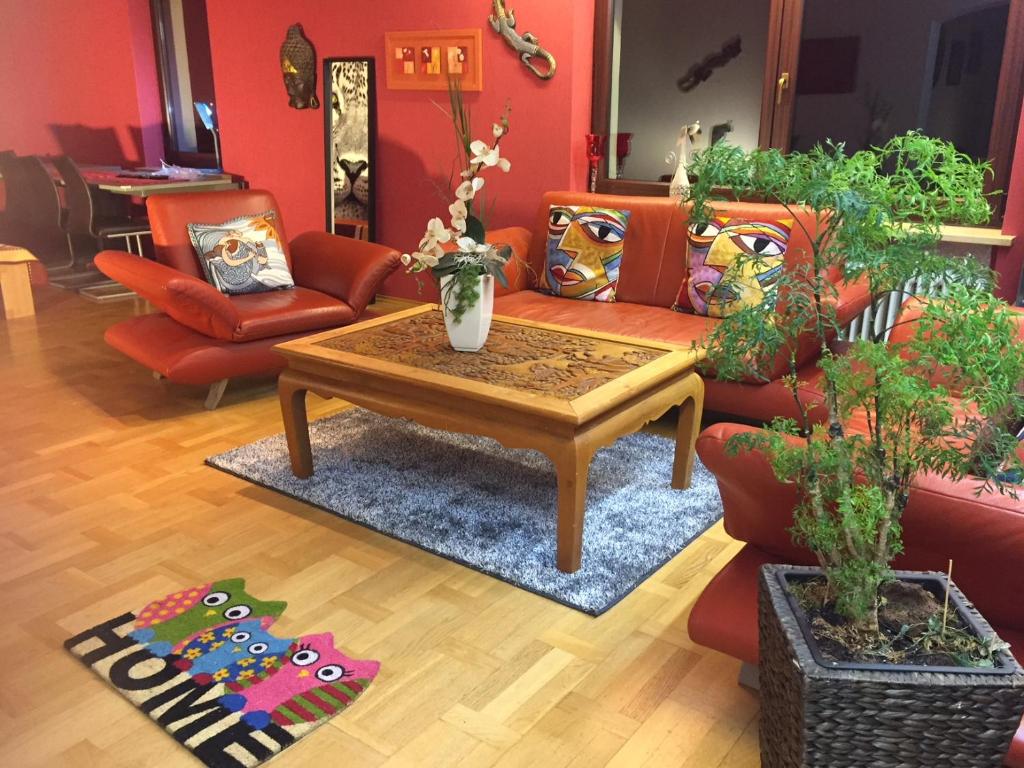 a living room with red walls and a coffee table at XXL Deluxe Living 125qm bei Nürnberg in Roßtal
