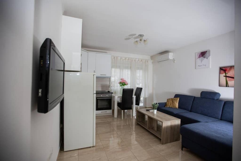 uma sala de estar com um sofá azul e uma cozinha em Apartment Mattias free private parking em Mostar