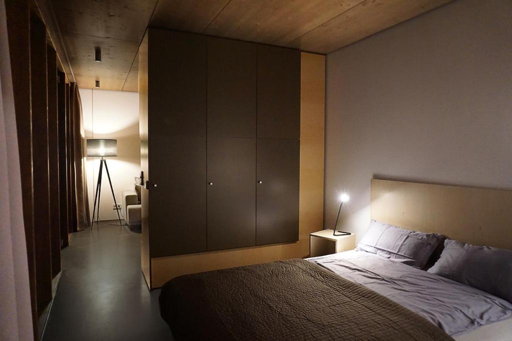 een slaapkamer met een groot bed en een lamp bij Design Ferienhaus nienrausch mit 2 Apartments in Timmendorfer Strand