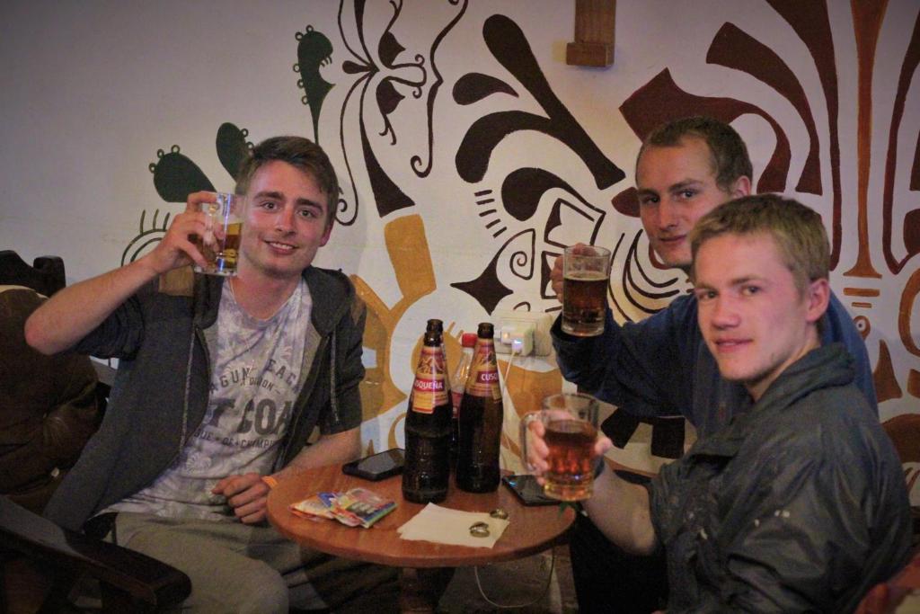 a group of men sitting around a table drinking beer at Vip House in Cusco