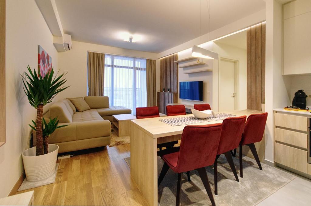 eine Küche und ein Wohnzimmer mit einem Tisch und Stühlen in der Unterkunft MVP apartment - Belgrade Waterfront in Belgrad