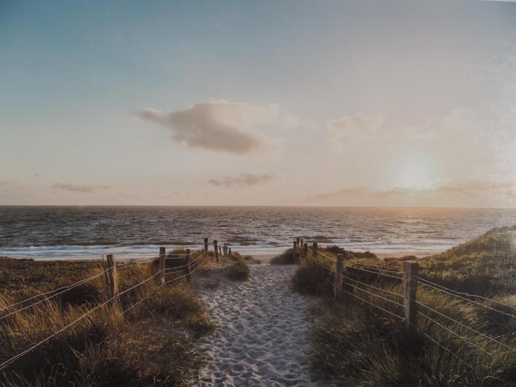a sandy beach with a fence and the ocean at Your Second Home-4 in Sindelfingen
