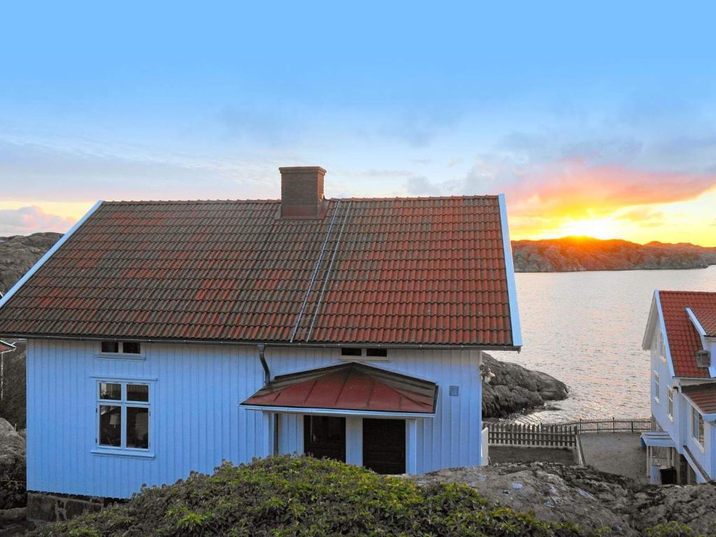 ハールハムにあるHoliday home SKÄRHAMNの水上赤屋根の青い家