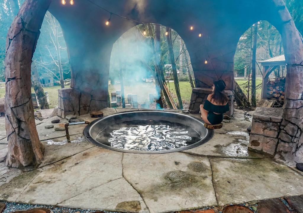 a woman sitting in a round pool of water in a playground at Paradise Village in Ashford