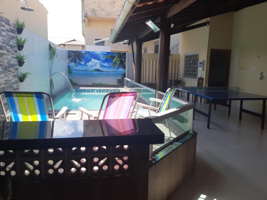 a patio with a table and chairs and a pool at Casa Salinópolis Atalaia in Salinópolis