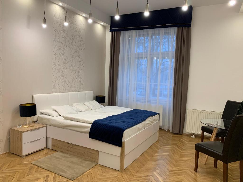 1 dormitorio con cama, mesa y ventana en W19 Apartments, en Miskolc