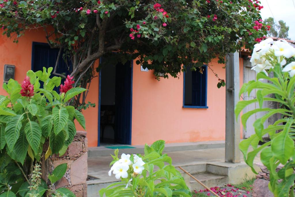 an orange house with flowers in front of it at Casa Cheia de charme in Mucugê