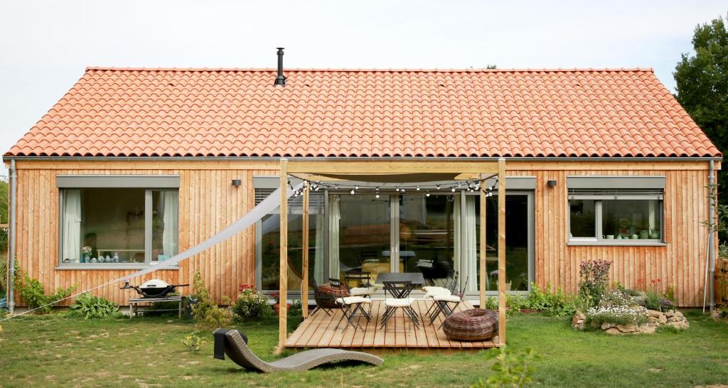 Cette petite maison en bois dispose d'une terrasse et d'une table. dans l'établissement Rejaillir, à Saint-Ours