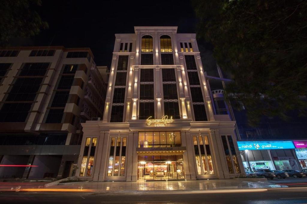 un edificio alto con luces encendidas por la noche en Seasons Park- mawasim al hay at hotel, en Yeda