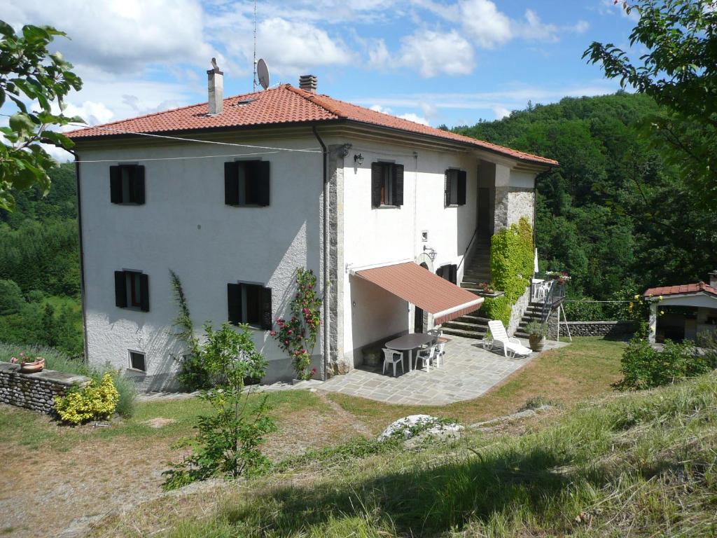 uma pequena casa branca com um telhado vermelho em Casa Pastano em Tornolo