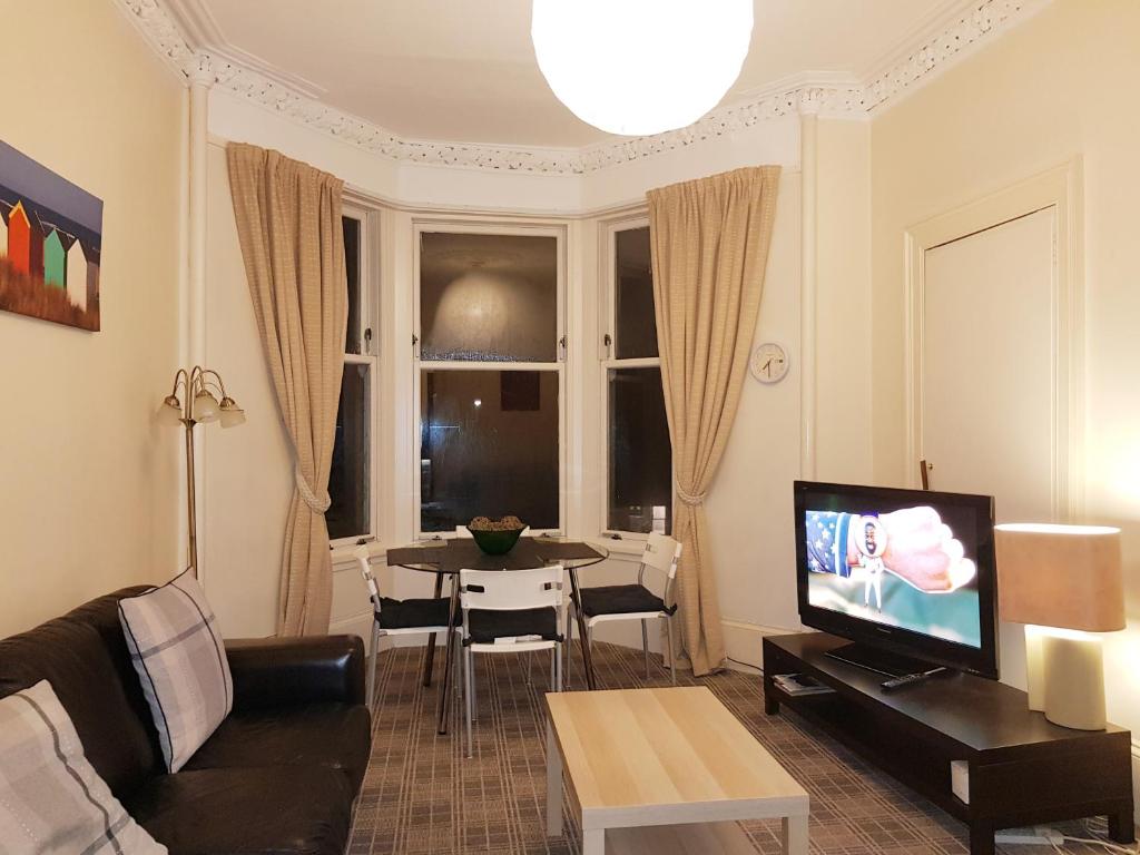 a living room with a couch and a table at Glen View Apartments in Port Glasgow