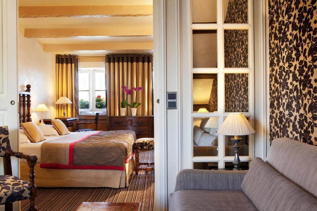 a hotel room with a bed and a couch at Hotel Left Bank Saint Germain in Paris