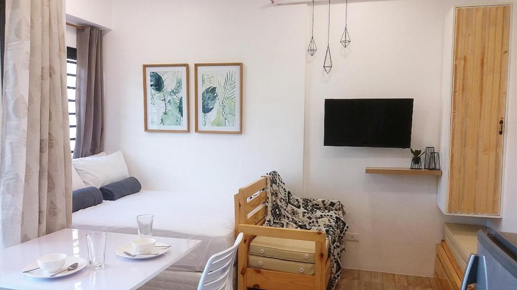 una pequeña sala de estar con una mesa y una cama en Mireya's Studio Condo at Goshen Towers - Session Road, en Baguio