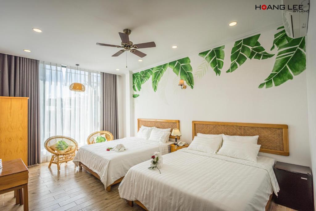 Habitación de hotel con 2 camas y ventilador de techo. en Viva Hotel Phú Yên en Phường Sáu