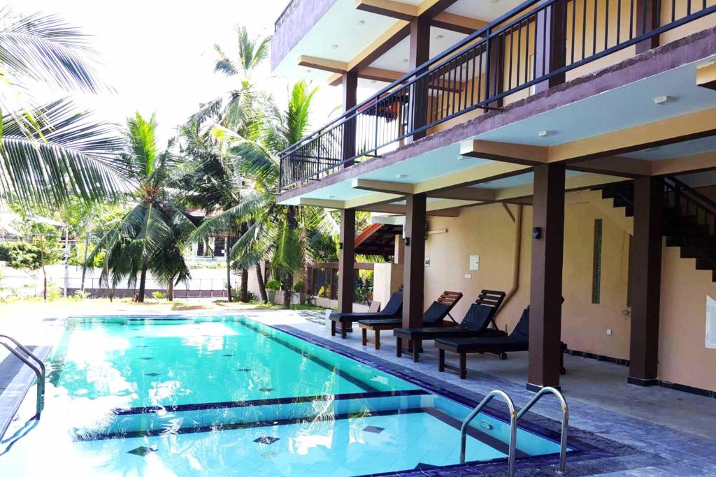 a swimming pool next to a building with a resort at Grand Residence in Tangalle
