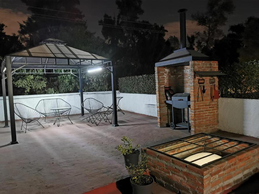 een patio met stoelen en 's nachts een grill bij Terraza Tlalpan-Acoxpa in Mexico-Stad