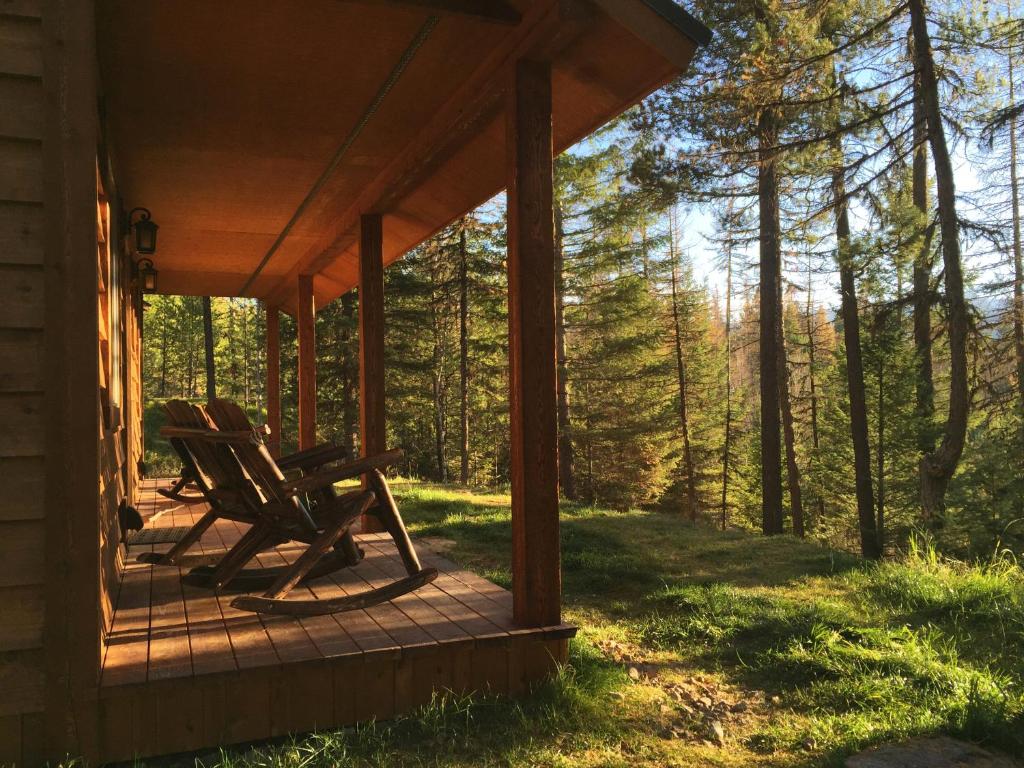 a rocking chair on a porch of a cabin in the woods at The Ridge At Glacier - Luxury Cabins in Coram