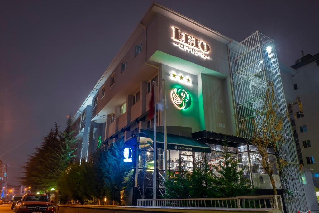 a lit up building with a sign on it at night at leto city hotel in Eskisehir