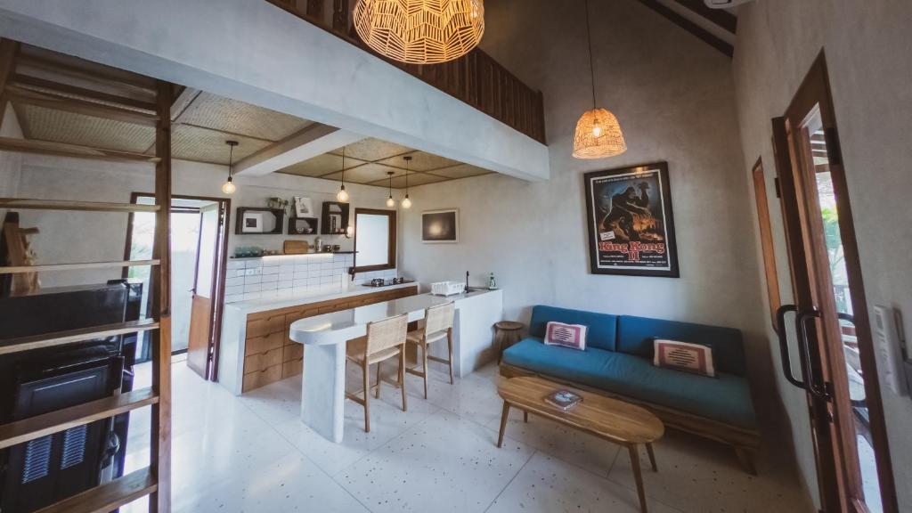een woonkamer met een blauwe bank en een bar bij Little Ripper Boutique Loft Studio in Tanah Lot