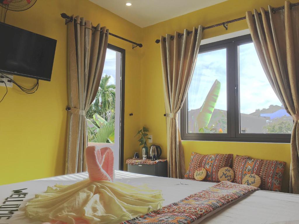 a bedroom with a bed with a large window at Longan Homestay in Hoi An