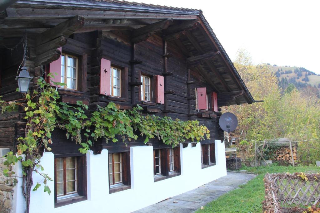 a wooden house with lots of windows and vines at Chalet Bergwelt in Frutigen