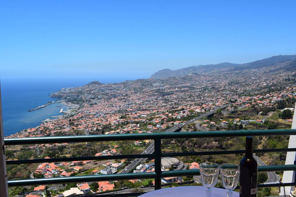 uma vista para a cidade a partir de uma mesa com copos de vinho em Bay View Apartment em Funchal