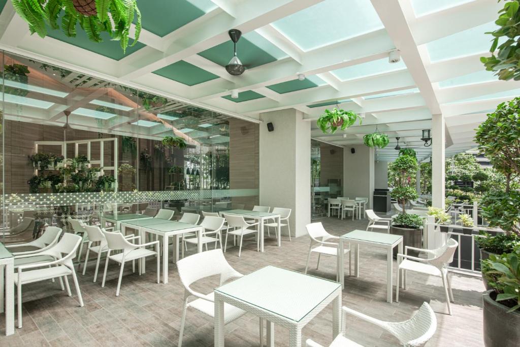 a restaurant with tables and chairs and plants at Komune Living in Kuala Lumpur