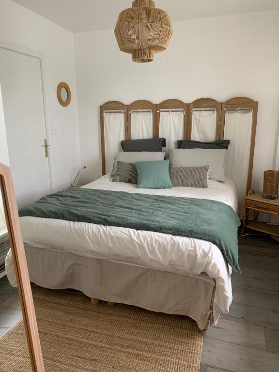 a bedroom with a large bed with a green blanket at Appart 24 avec vue Port in Ouistreham