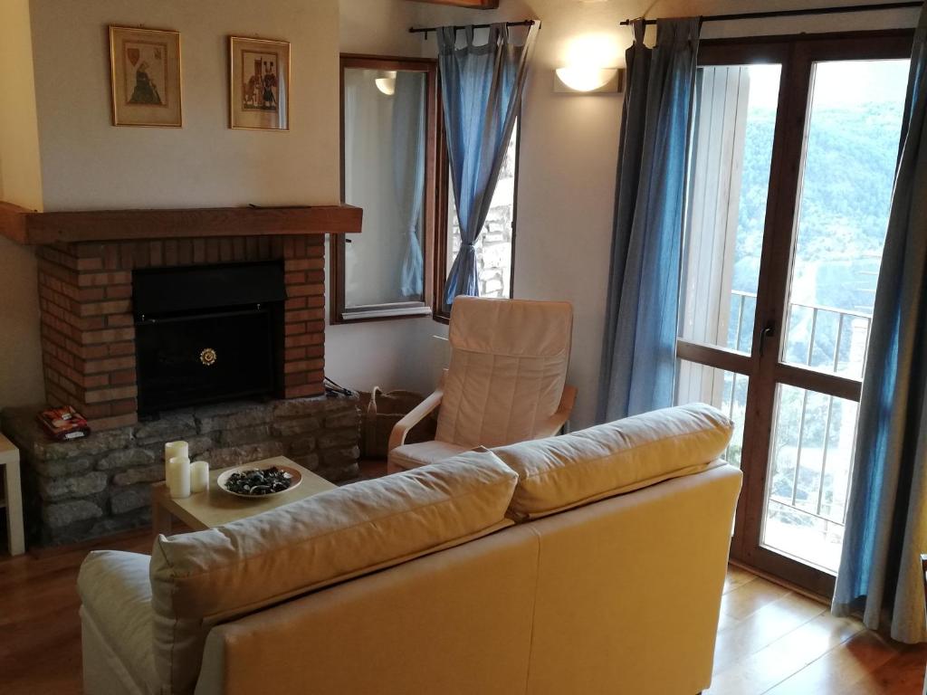 sala de estar con sofá y chimenea en Coqueto Apartamento Dúplex en Roda de Isábena, en Roda de Isábena