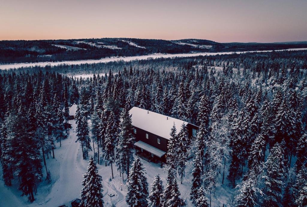 ein Gebäude inmitten eines schneebedeckten Waldes in der Unterkunft Villa Happy Fox in Rovaniemi