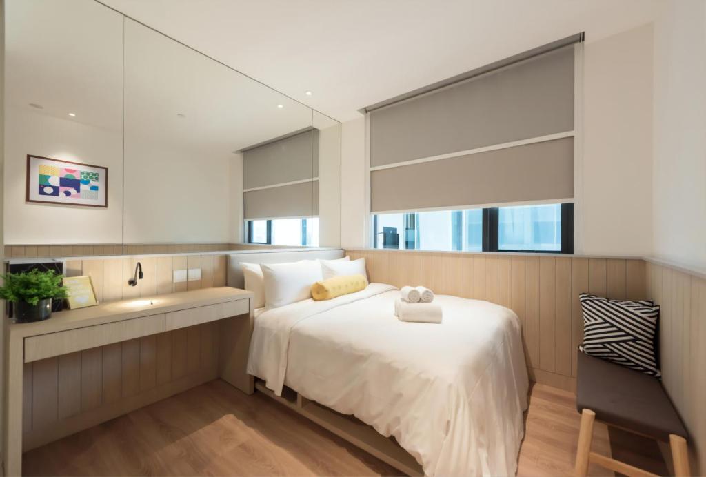 a bedroom with a large bed and a sink at Komune Living in Kuala Lumpur