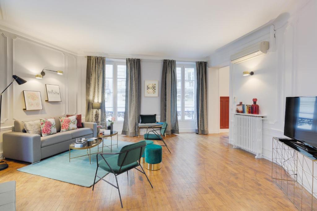 - un salon avec un canapé et une télévision dans l'établissement Sweet Inn - Boetie V, à Paris