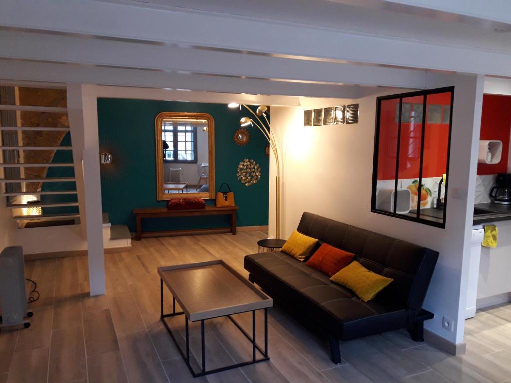 uma sala de estar com um sofá e uma mesa em CENTRE HISTORIQUE T3 DUPLEX PARKING Gratuit em Béziers