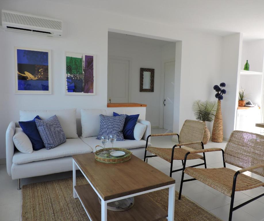 sala de estar con sofá blanco y sillas en Apartamento Son Parc Menorca, en Son Parc