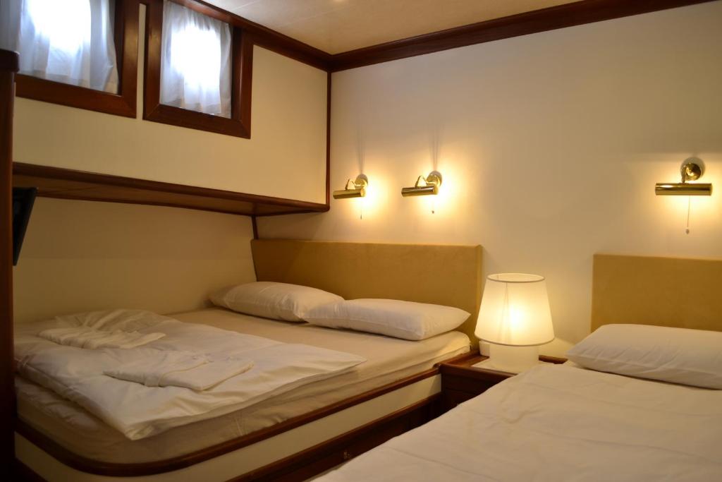 two beds in a small room with two lamps at DVI MARIJE in Palermo