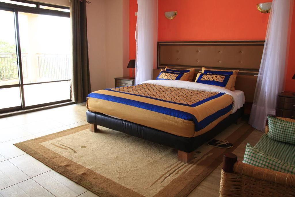 a bedroom with a large bed with an orange wall at Milimani Beach Resort in Kisumu