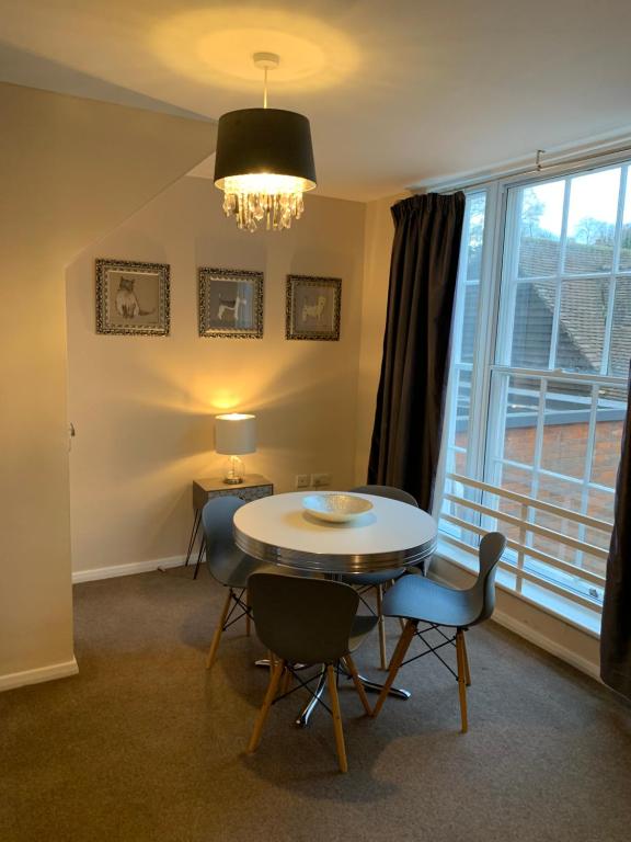 een eetkamer met een tafel en stoelen en een raam bij Market Hill Apartments in Royston