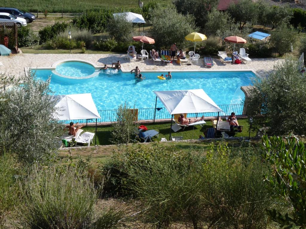 a large swimming pool with people in a resort at Residence Il Monastero in Pomarance