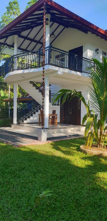 a large house with a balcony and a yard at Ivory Villa in Ahangama