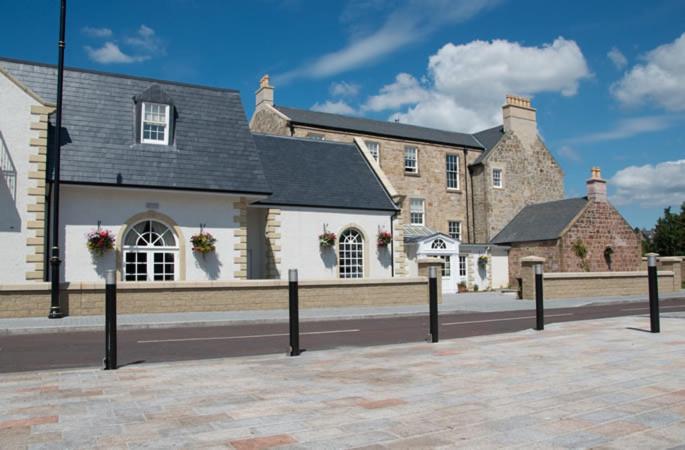 een groep gebouwen op een straat aan de voorzijde bij Dumfries Arms Hotel in Cumnock