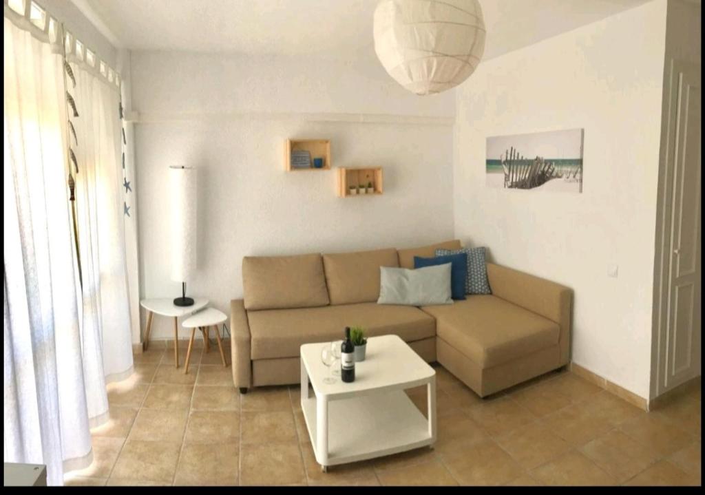 ein Wohnzimmer mit einem Sofa und einem Tisch in der Unterkunft Acogedor apartamento junto al mar in Las Negras